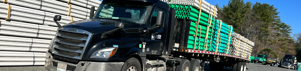 Steel Pipe Distribution and Delivery PVC pipe being loaded onto a delivery truck at a distribution facility